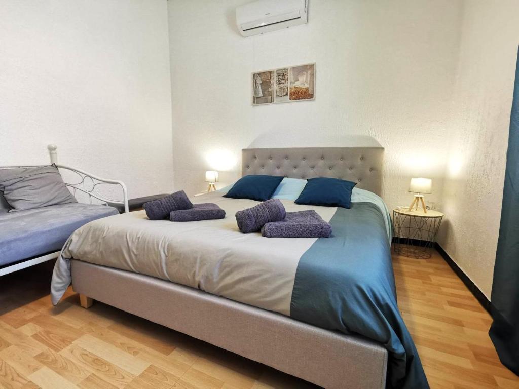 米拉马斯L'hypercentre - Clim - Terrasse - WIFI的一间卧室配有一张大床,上面有紫色枕头