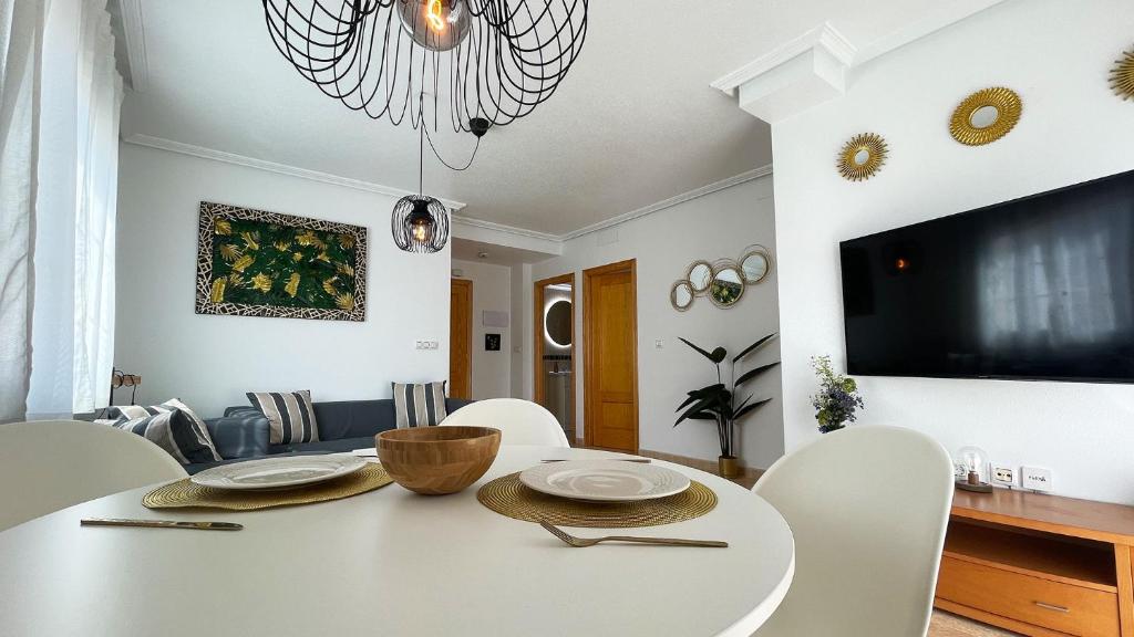 圣佩德罗-德尔皮纳塔尔Low Price Modern Apartment sleeps 4 Fully Aircon的白色的用餐室配有白色的桌椅