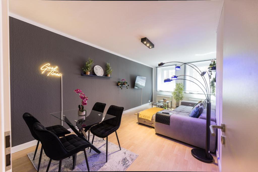 汉堡The Harbour Apartment 2的客厅配有紫色沙发和黑色椅子