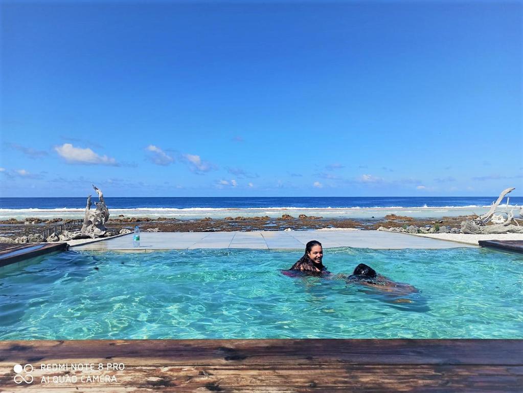 法卡拉瓦FAKARAVA - Teariki Lodge 2的躺在海洋附近的游泳池中的女人