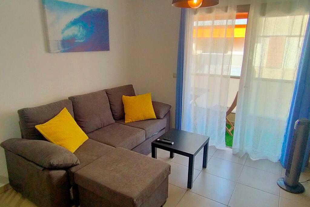 阿尔卡拉Alcalá Center Playa的客厅配有棕色沙发和黄色枕头