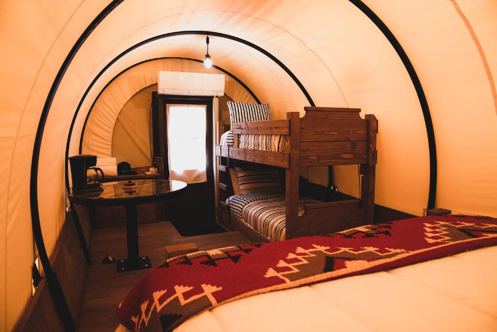 阿马里洛The Big Texan - Cabins and Wagons的帐篷内带一张床和一张桌子的房间