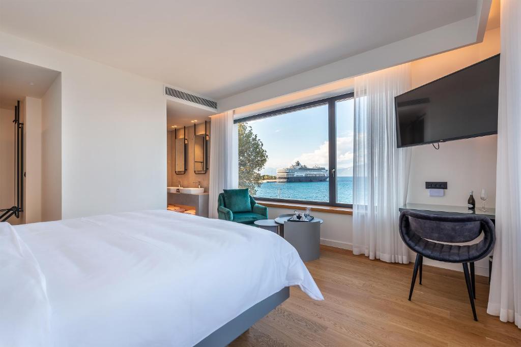艾伊翁Amario Suites Hotel的一间卧室设有一张大床和一个大窗户