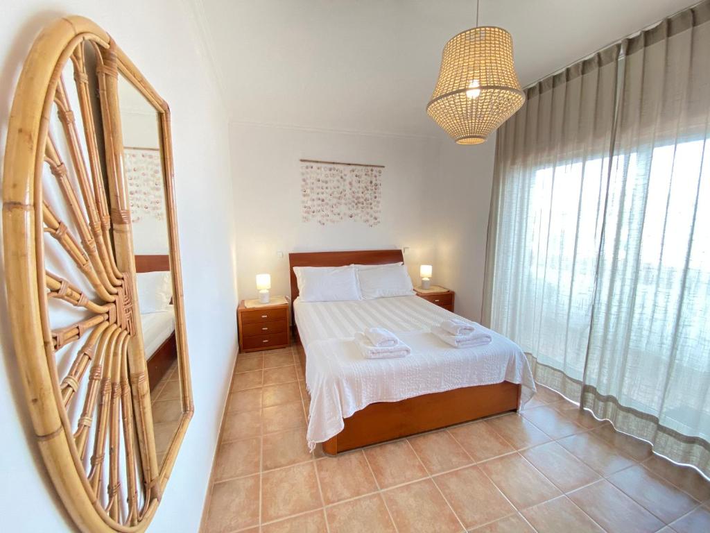 布尔高Aloha Burgau Guesthouse的一间卧室配有一张床和一面大镜子