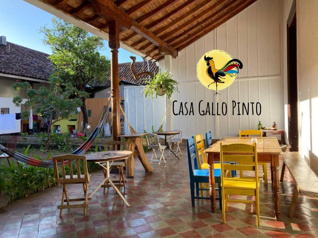 格拉纳达Casa Gallo Pinto的一个带桌椅的庭院和一只鸟的墙上