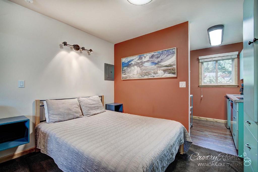 布雷肯里奇Completely Renovated Unit, Trendy Top Floor with Many Onsite Amenities PM7D的一间卧室配有一张橙色墙壁的床