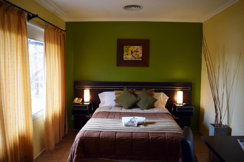 埃利萨镇Hotel Suite & Spa Verdesolaro的一间绿色卧室,配有一张床和两盏灯