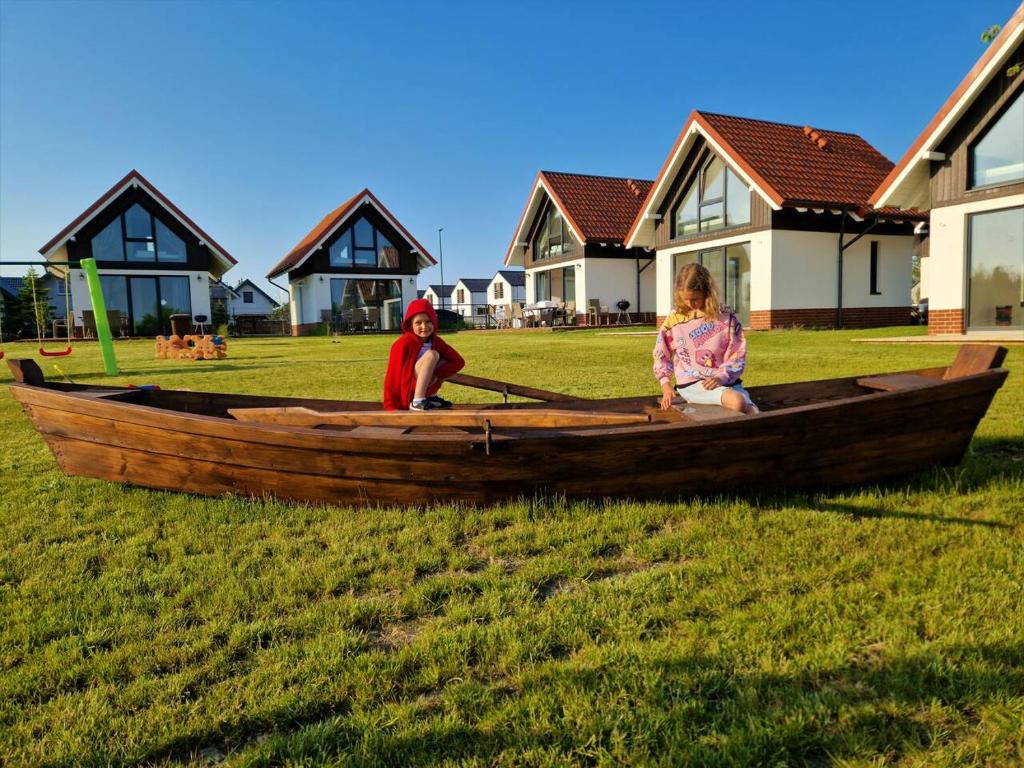 加茨比亚格拉Kaszubia的两个孩子坐在木船上的草地上