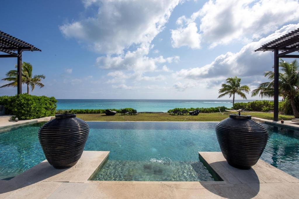 总督港Ananda House estate的两个大花瓶,坐在一个俯瞰大海的游泳池里