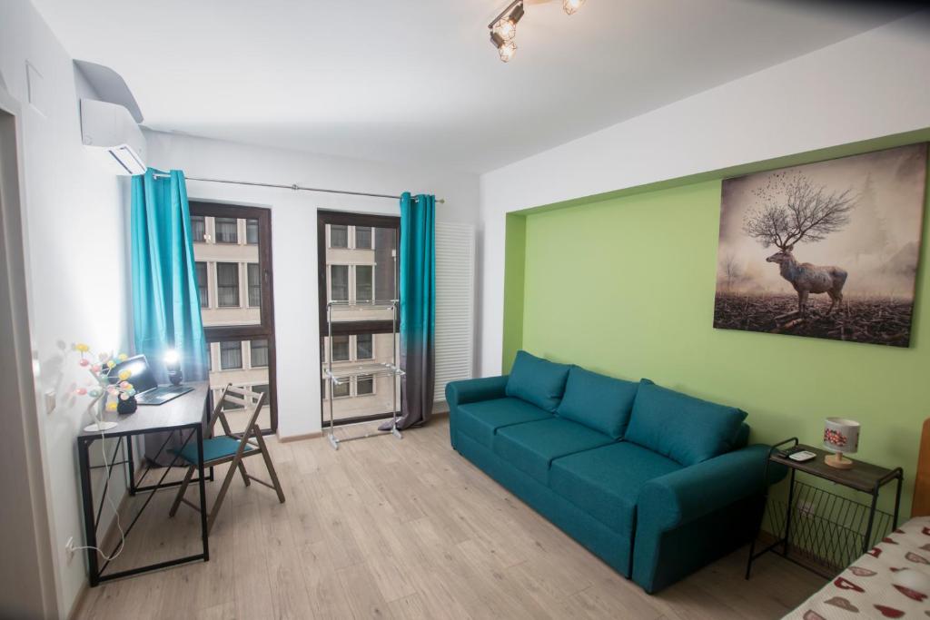 布加勒斯特Studio Moghioros rezidence 2的客厅配有蓝色的沙发和书桌
