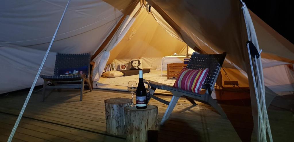AlonnahBase Glamp Bruny Island的配有2把椅子和1瓶葡萄酒的帐篷