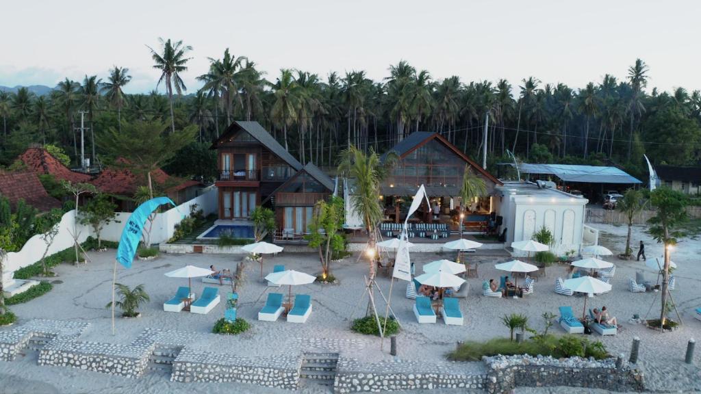 珀尼达岛Khamara Nusa Penida的享有带椅子和遮阳伞的度假村的空中景致