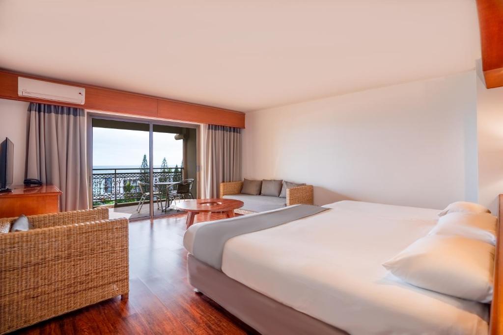 努美阿诺瓦塔酒店的酒店客房设有一张大床和一个阳台。