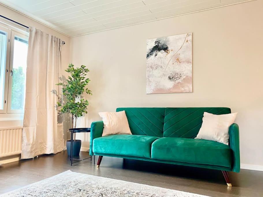 图尔库Beautiful 2 bedroom & Free parking的客厅设有一张绿色沙发,配有窗户