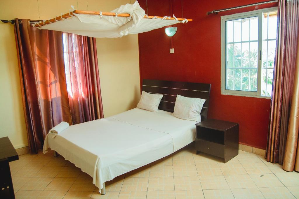 马哈赞加Salama Hôtel Majunga的一间红色客房内的卧室