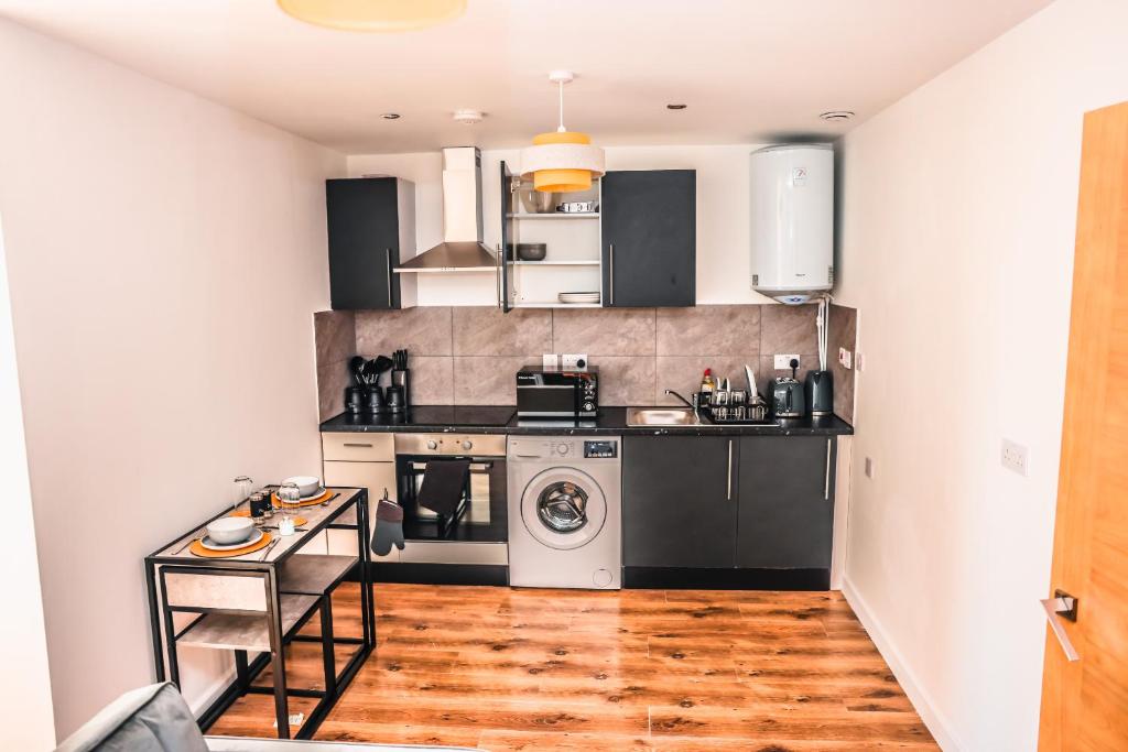伦敦Cosy Two Bedroom Apartment的厨房配有黑白电器,铺有木地板
