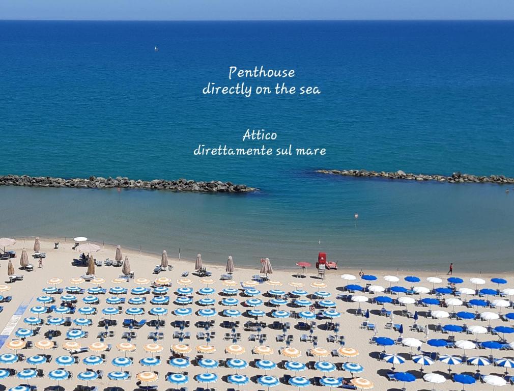 蒙特西尔瓦诺La Terrazza sul Mare的海滩上有很多遮阳伞和海洋