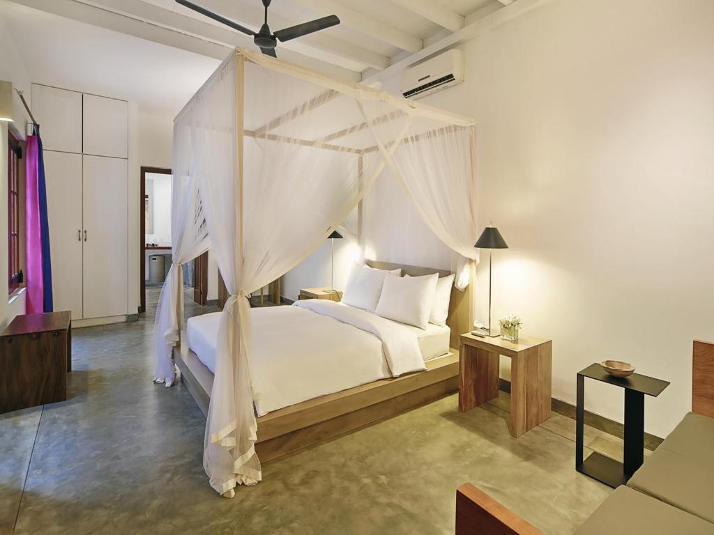 高尔普瑞特斯堡酒店的一间卧室配有一张带天蓬的白色床