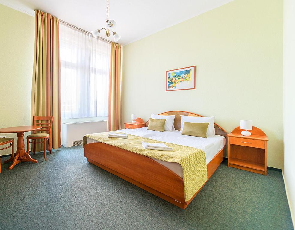 布达佩斯布达佩斯巴罗斯城市酒店的酒店客房配有一张床铺和一张桌子。