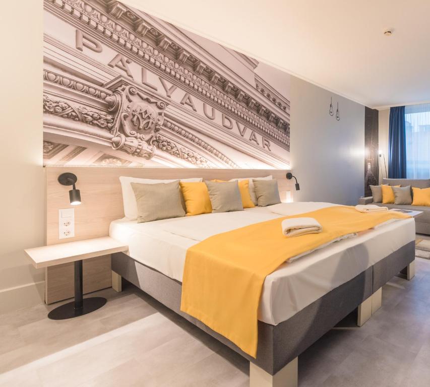 布达佩斯Impulso Fashion Hotel的一间卧室配有一张带黄色毯子的大床