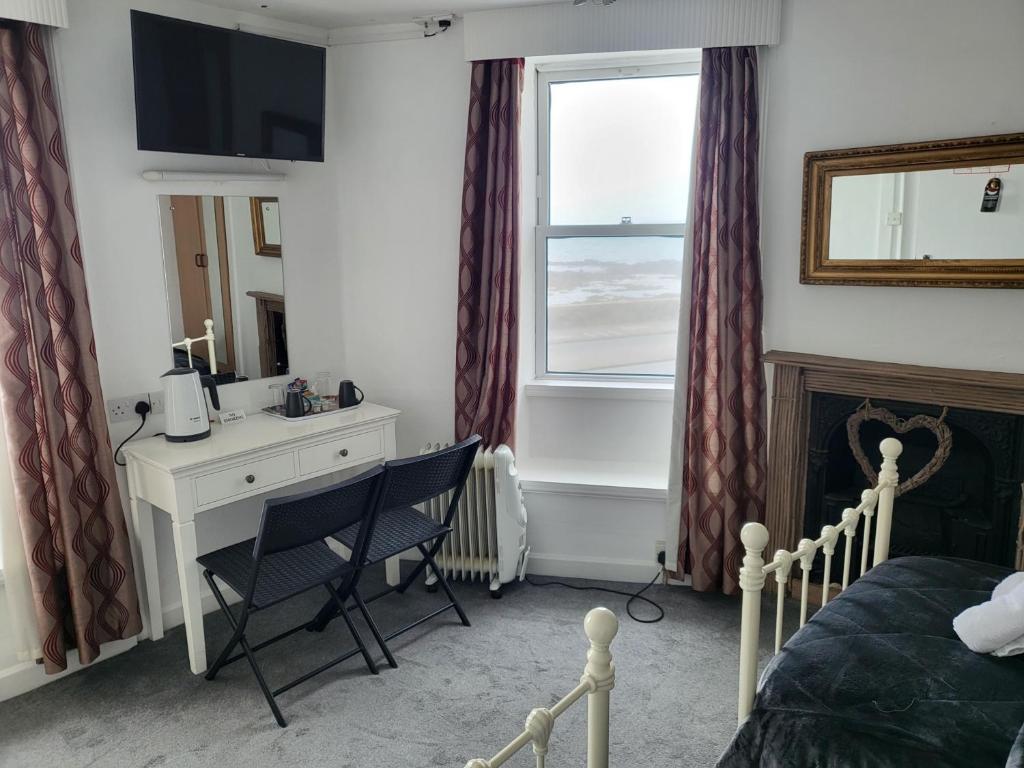 圣彼得港圣乔治旅馆的一间卧室配有书桌、床和窗户。