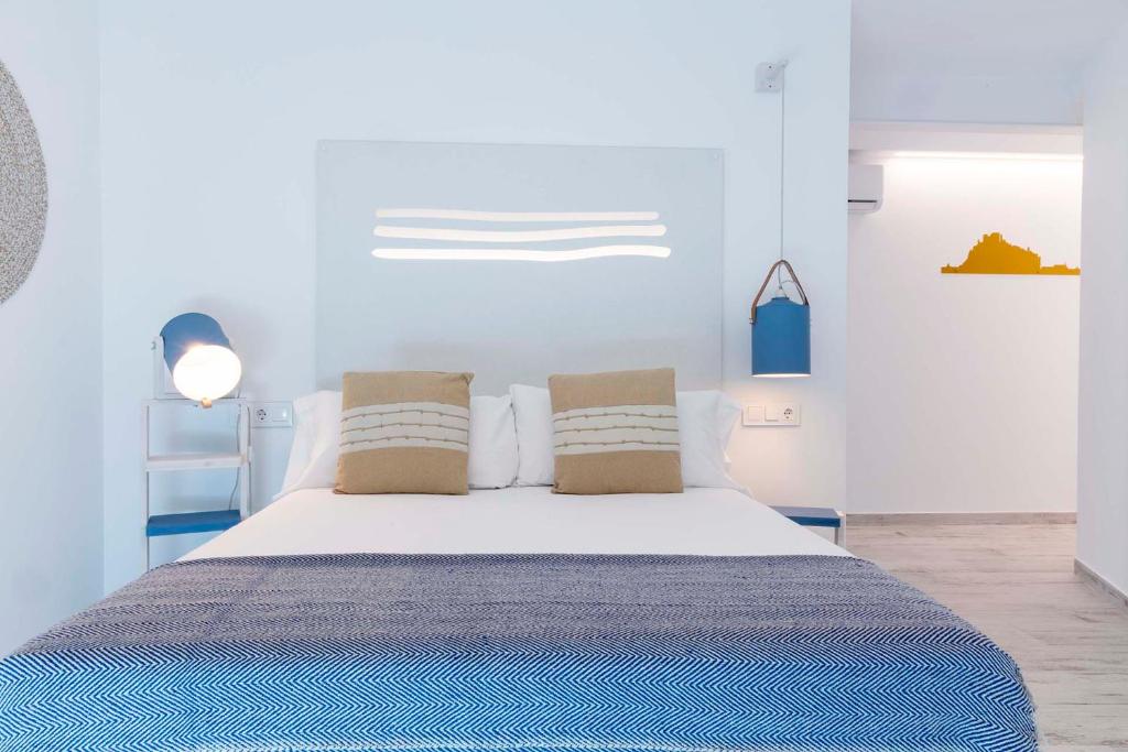 佩尼斯科拉Hostal Boutique La Mar Serena的卧室配有一张带两个枕头的大白色床