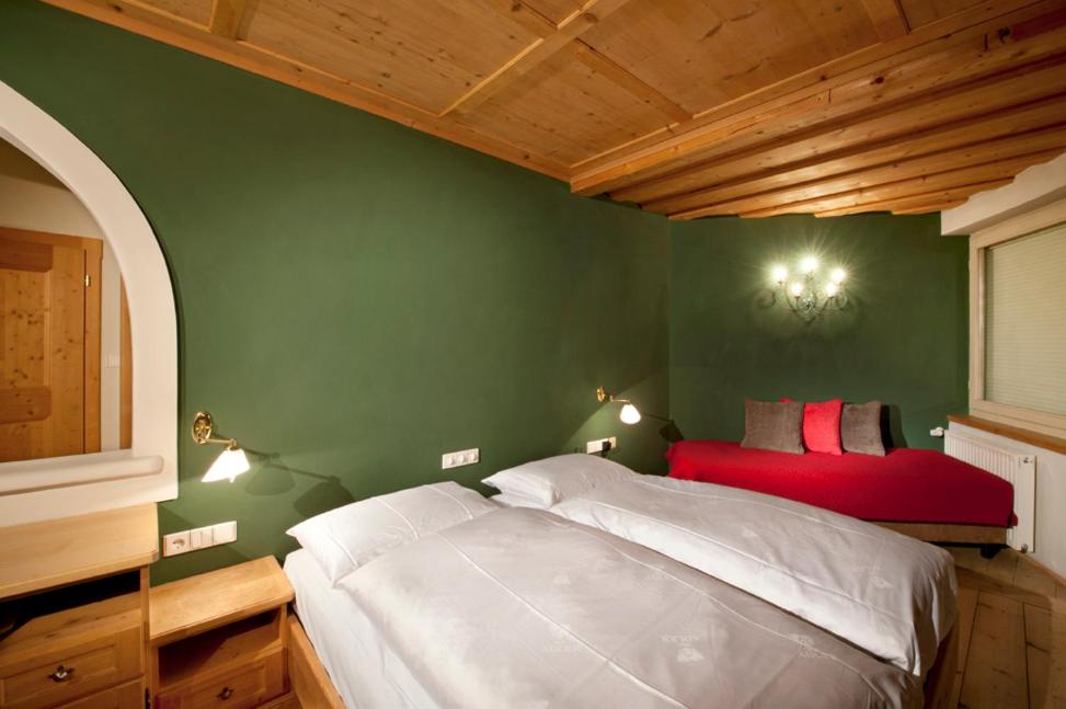 维拉巴萨阿德勒公寓的卧室配有白色的床和绿色的墙壁