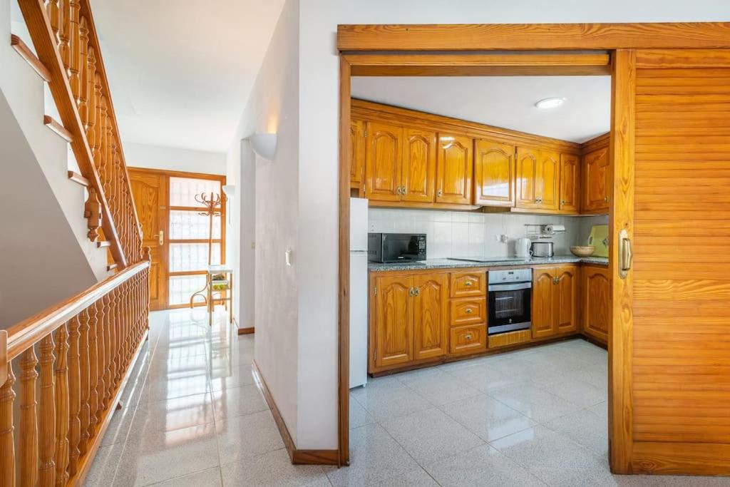 塔马留Seamount, a beautiful house overlooking Tamariu的厨房配有木制橱柜和炉灶。