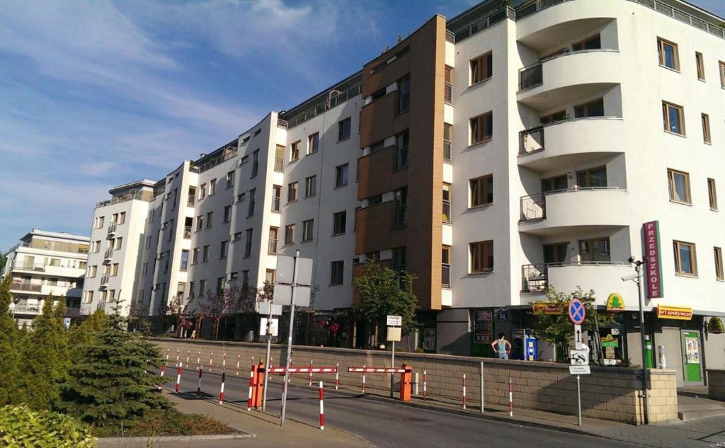 华沙Warszawa Bemowo Pokoje的前面有橙色屏障的街道上的建筑
