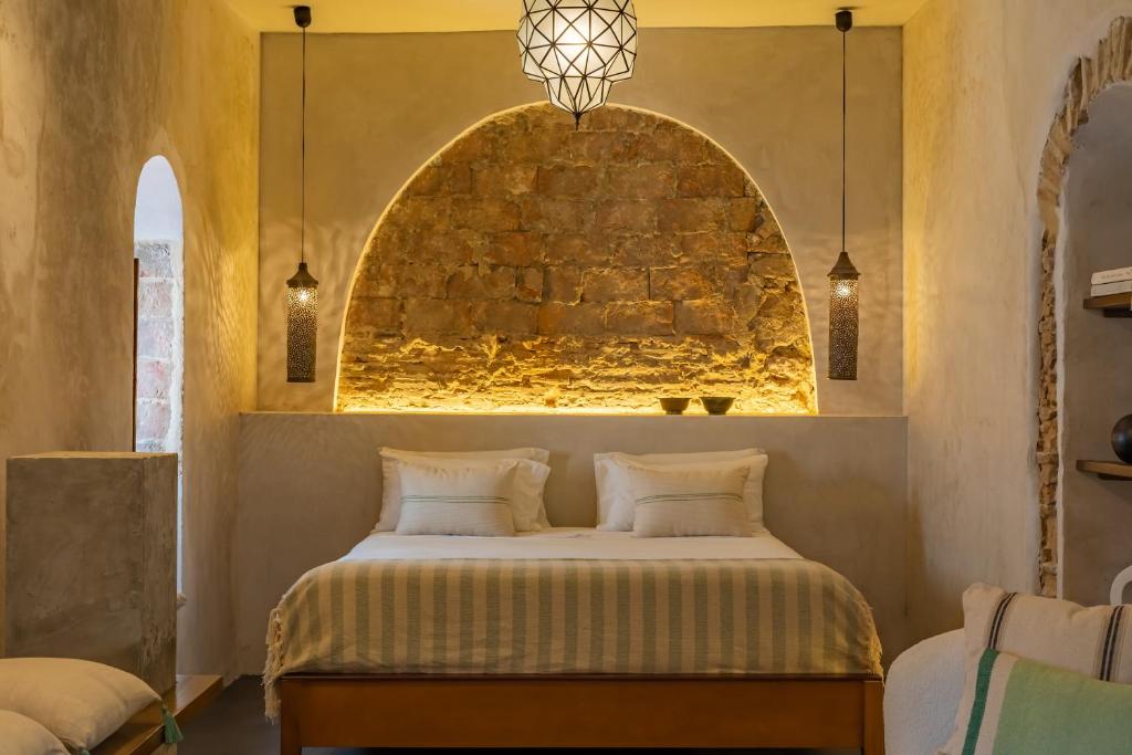 塔里法The Riad - Adults Only的一间卧室配有一张石墙床