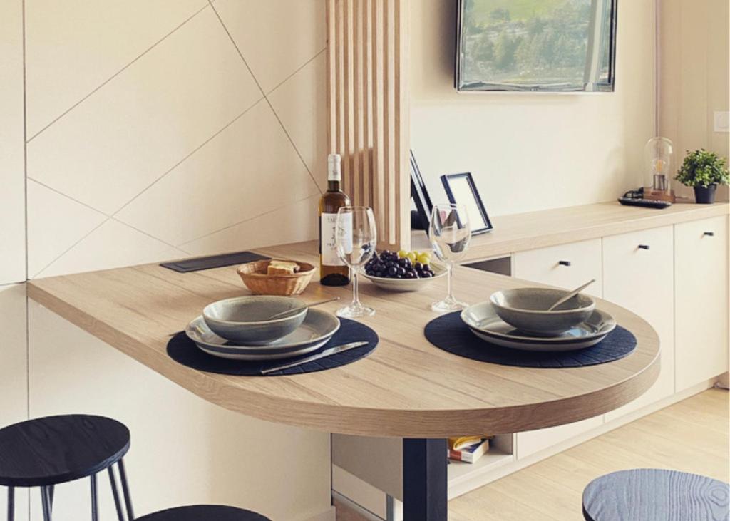 阿雷特FLOR de MONTANHAS - 4PERS - Appart vacances的餐桌,配有盘子和酒杯
