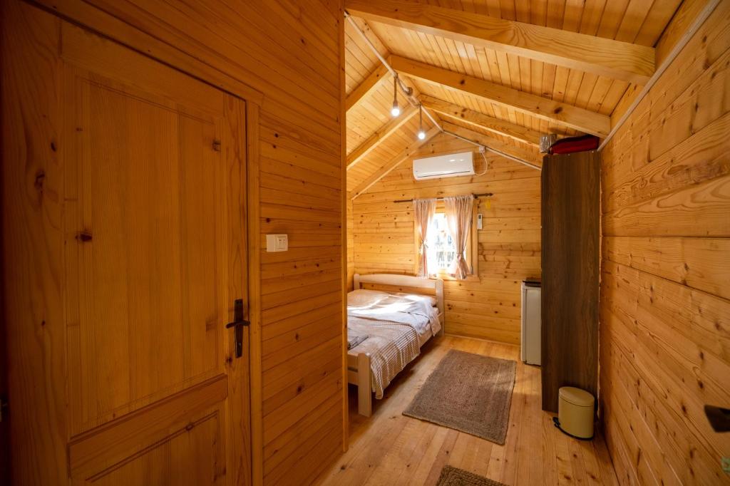 波德戈里察Via river的木制客房内的一间卧室,配有一张床