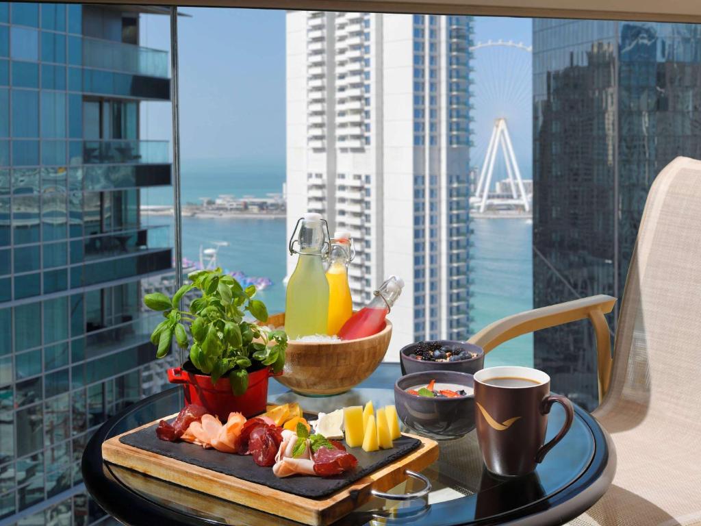 迪拜朱美拉海滩瑞享酒店的一张桌子上的盘子,享有城市美景