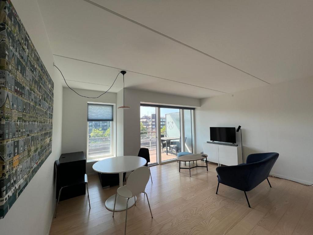哥本哈根Copenhagen centre luxury apartment - Østerbro的客厅配有桌椅和电视。
