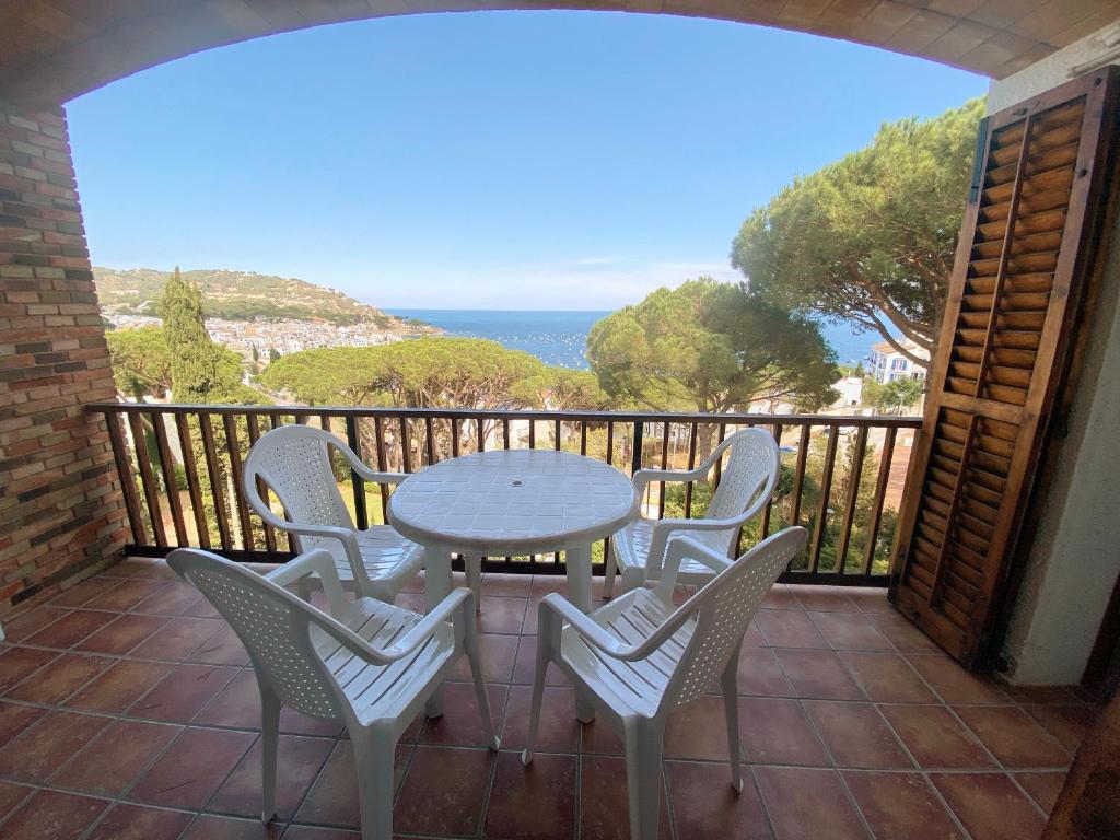 卡莱利亚德帕拉弗鲁赫尔Apartamento con espectaculares vistas al Mediterráneo的阳台的天井配有桌椅