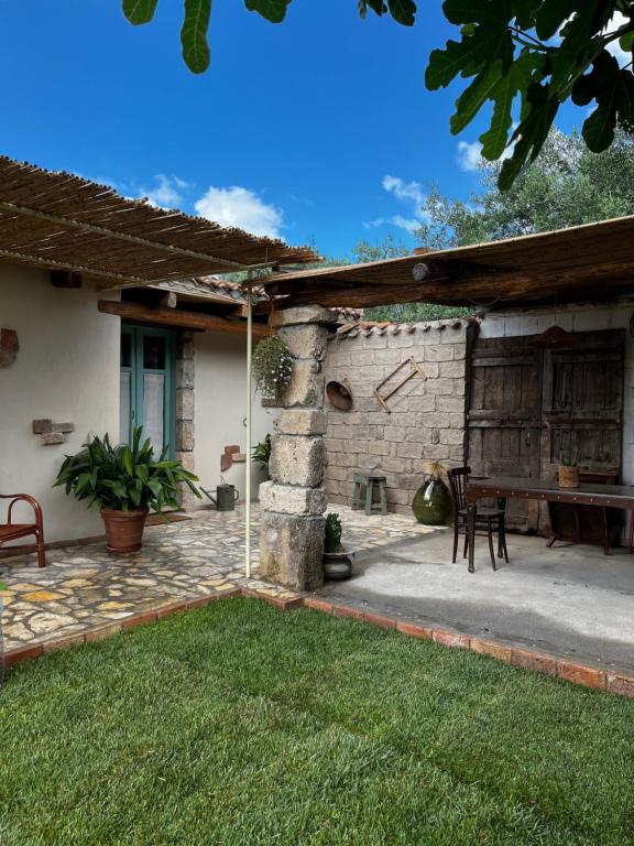 奥里斯塔诺Graziosa stanza campidanese Su terzu的一个带桌子和石墙的庭院
