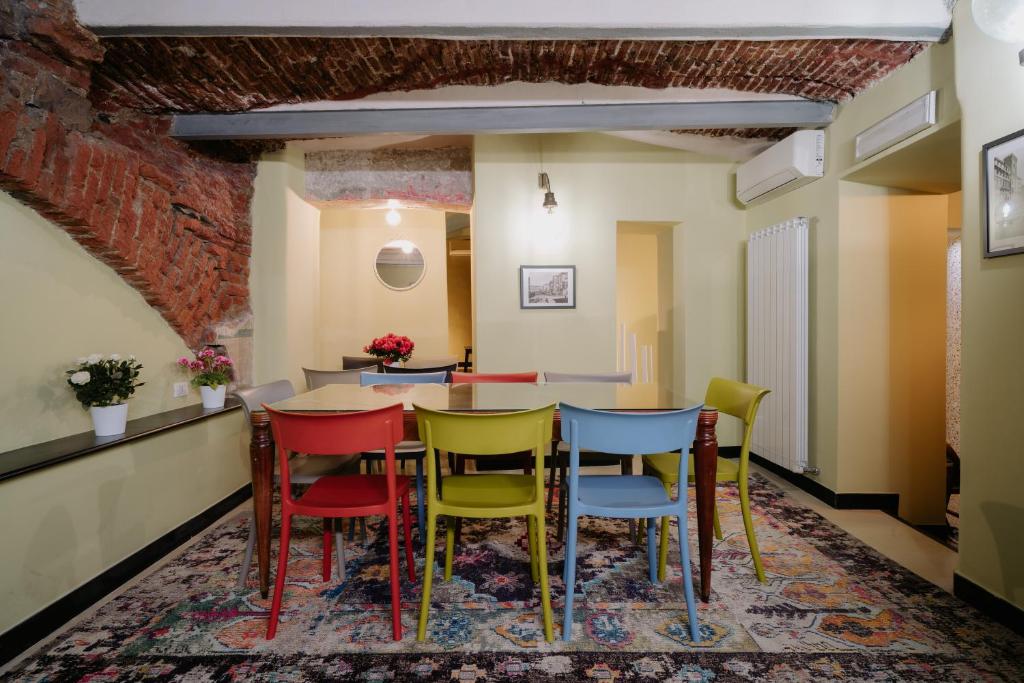 热那亚Le stanze del Piccadilly的配有桌子和五颜六色椅子的房间