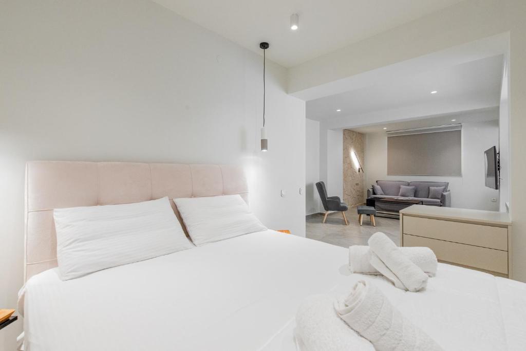 爱琴娜岛Gemela AllstarBoutique in Aegina A的一间带白色床的卧室和一间客厅