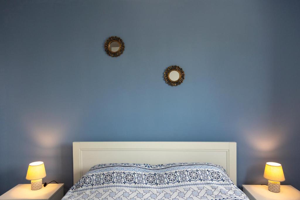 布林迪西Casa via materdomini的一间卧室设有蓝色墙壁、一张床和两盏灯。