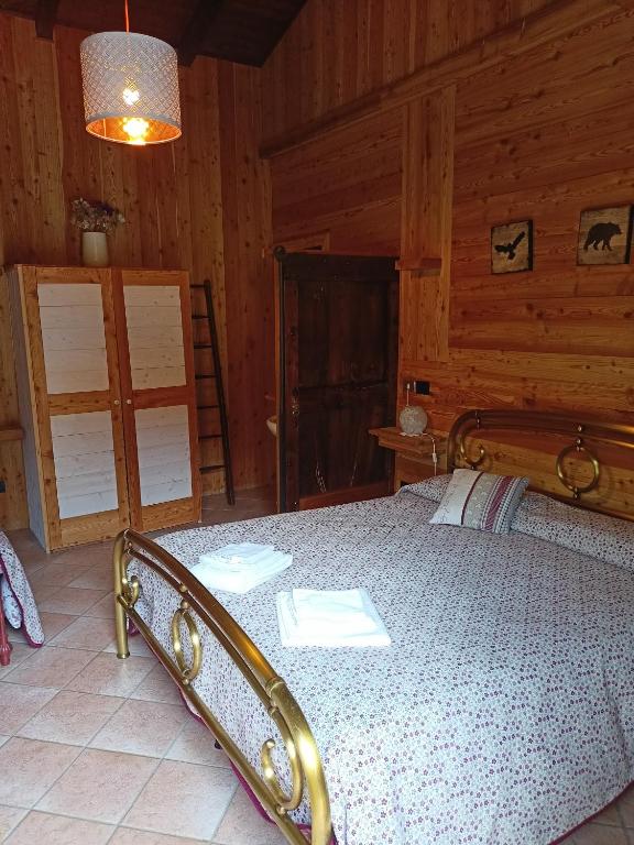Bobbio PelliceL'Alpina Affittacamere的小屋内一间卧室,配有一张床