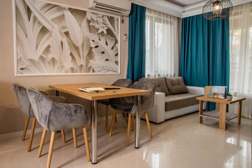 瓦尔纳Vemara City Apart Hotel的客厅配有桌椅和沙发