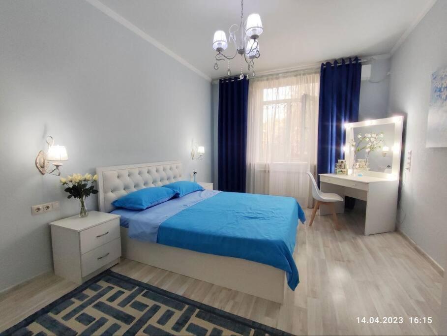 阿拉木图Стильный уют в центре的一间卧室配有蓝色的床和一张书桌