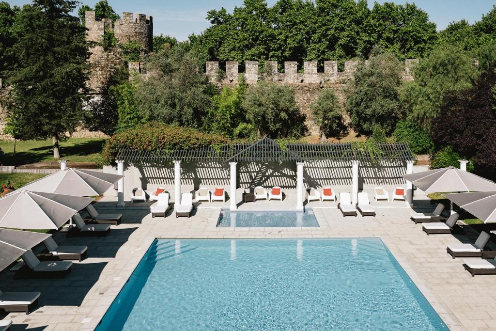 埃武拉AR城墙酒店的一个带椅子的游泳池和一个城堡