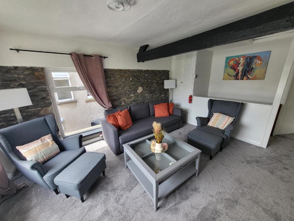 卡特梅尔Courtyard Cottage的客厅配有沙发、椅子和桌子
