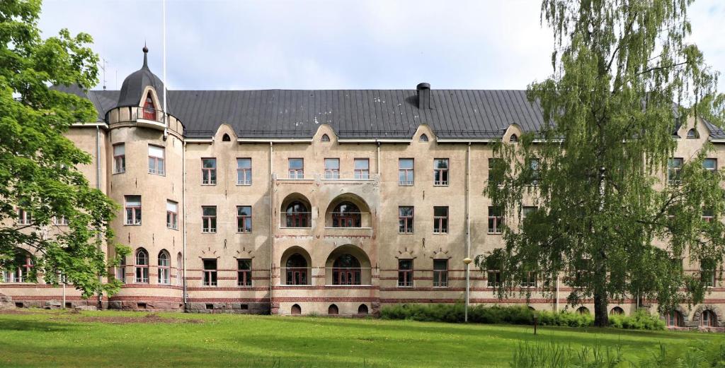 赫尔辛基Forenom Hostel Röykkä的一座大型石头建筑,有黑色的屋顶