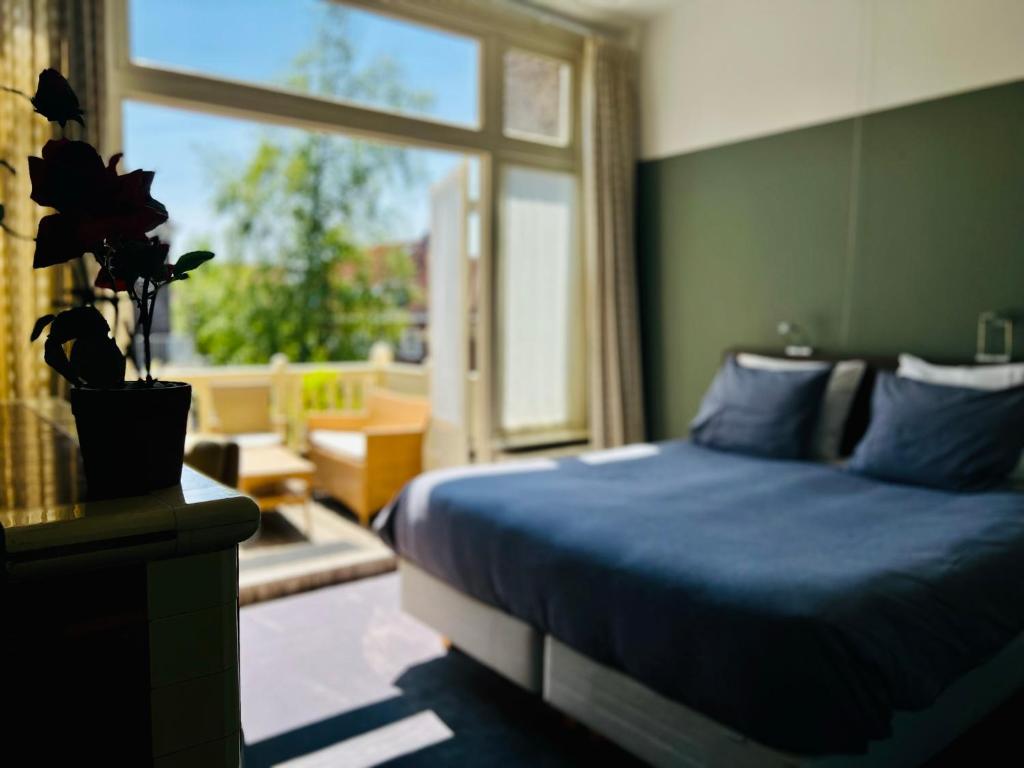 埃因霍温茱莉安娜住宿加早餐旅馆的一间卧室设有蓝色的床和窗户。