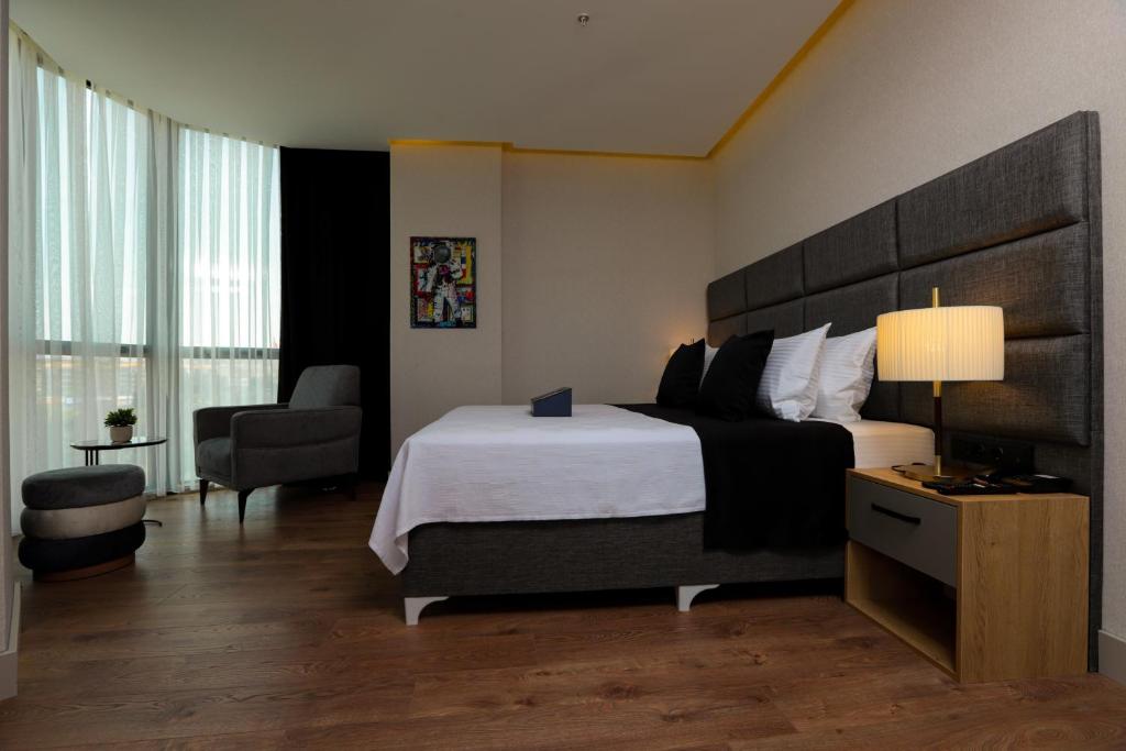 乔尔卢Brand Business Hotel的酒店客房带一张大床和一把椅子