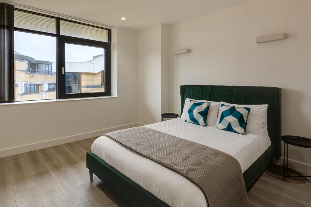 布伦特福德Brentford Apartments by Charles Hope的一间卧室设有一张大床和一个窗户。