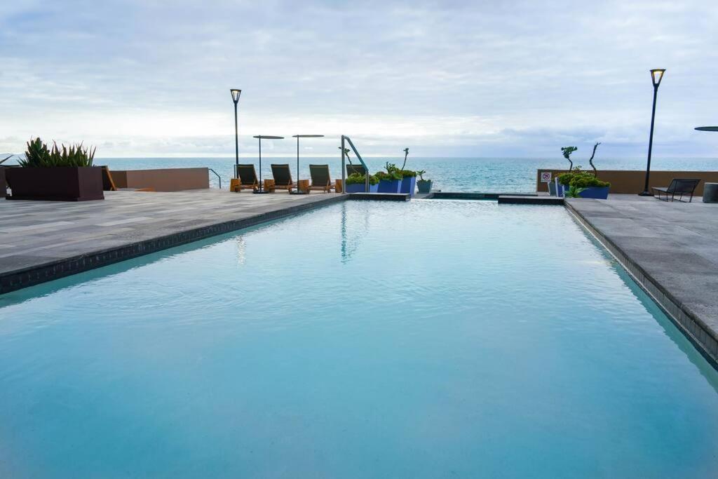 提华纳Hotel Suite Luxe Sunset的一座背景海洋的游泳池