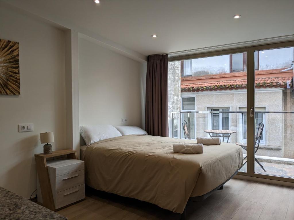 坎加斯德穆拉索Casa Pintáns的一间卧室设有一张大床和一个大窗户